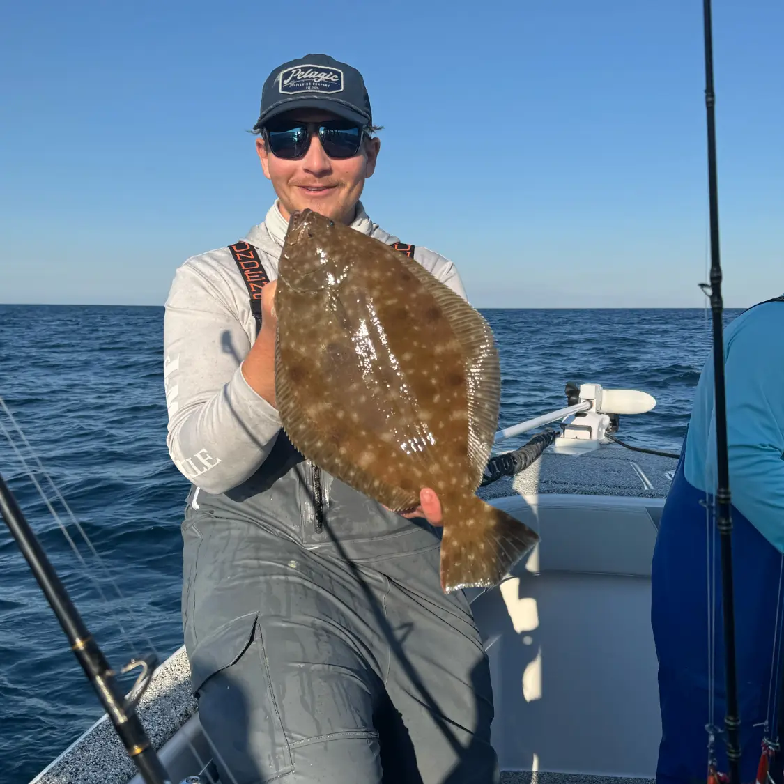 Angler holding a nice flounder on the boat during a Destin fishing trip with Finatical Charters.