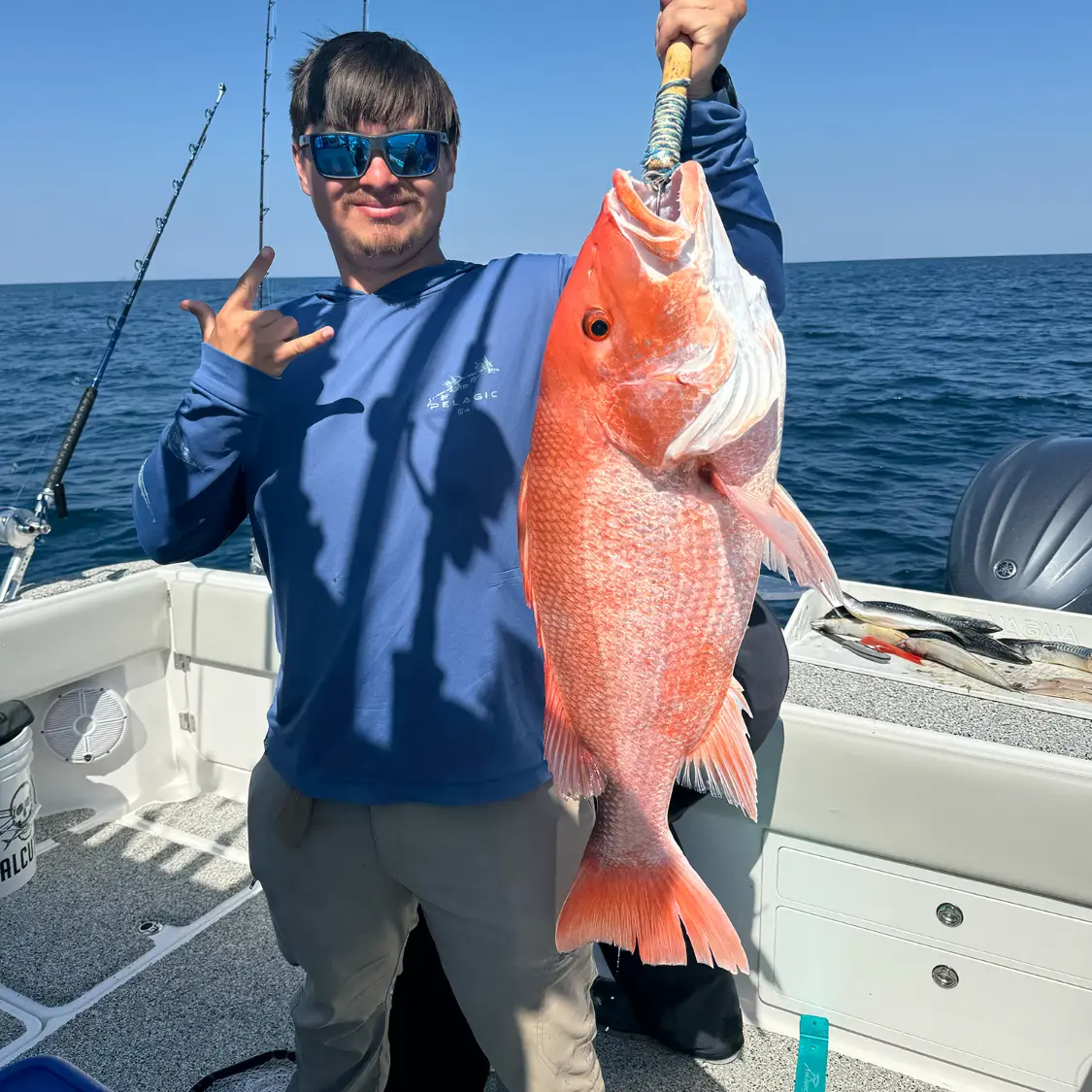 Angler holding a beautiful red snapper on the boat during a Destin fishing charter with Finatical Charters.